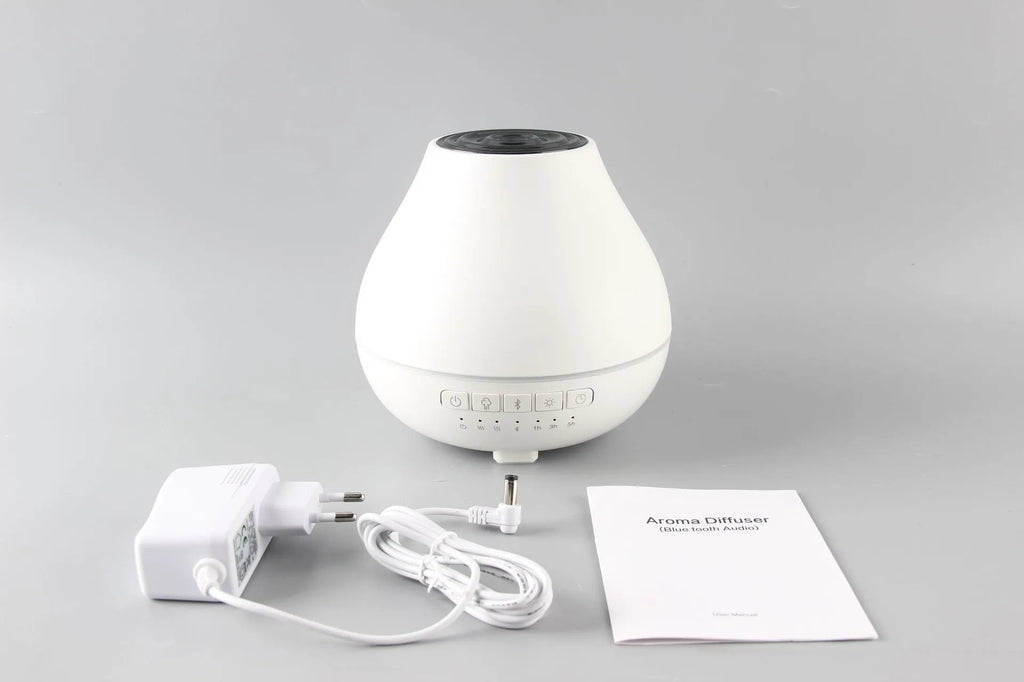 White round Bluetooth humidifier and aroma diffuser with night light on wooden surface