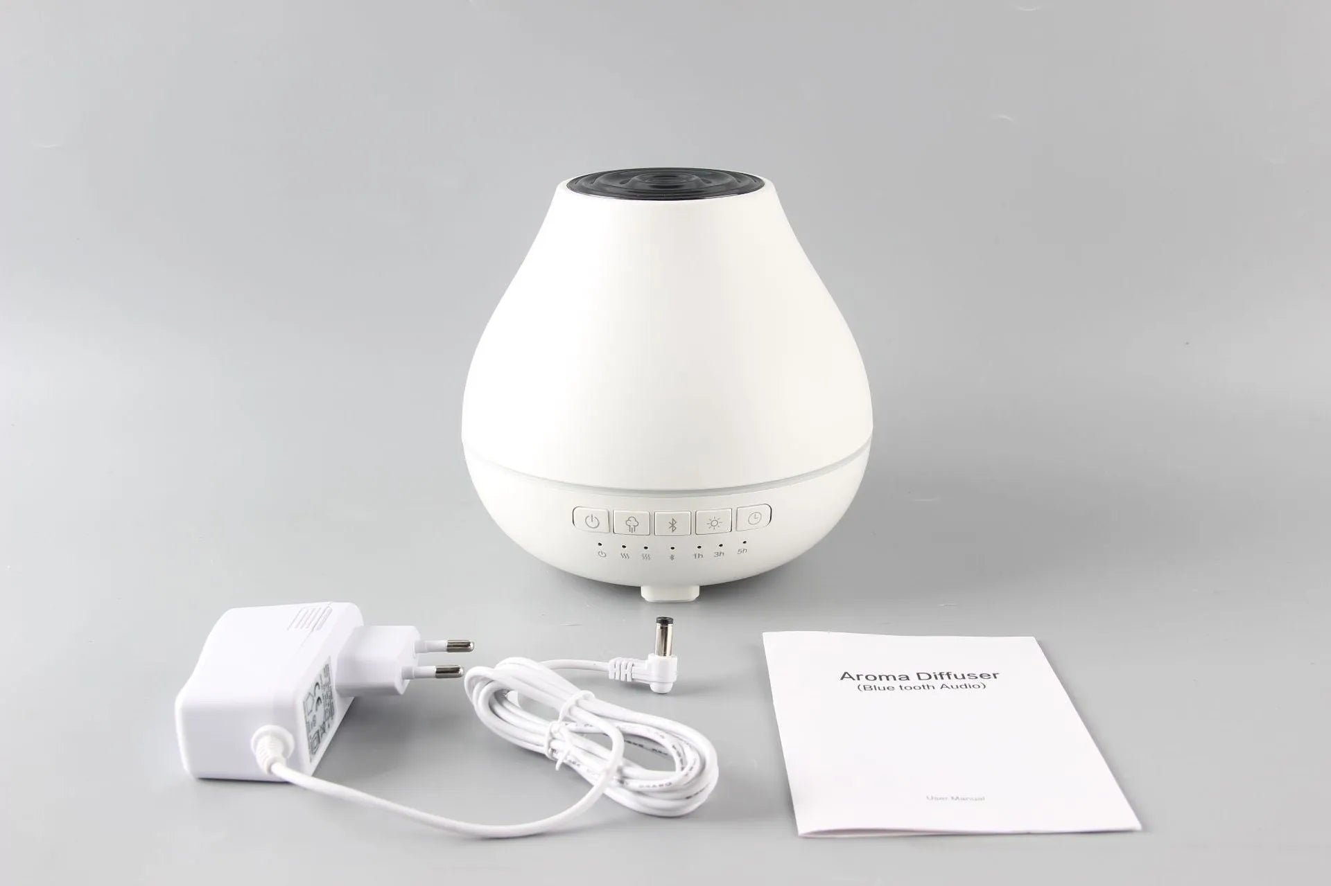 White round Bluetooth humidifier and aroma diffuser with night light on wooden surface