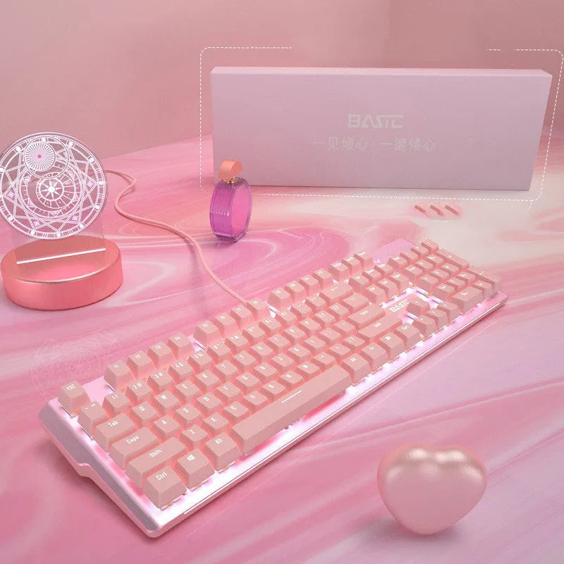 Pink wired mechanical keyboard and matching mouse with green switches on a desk.