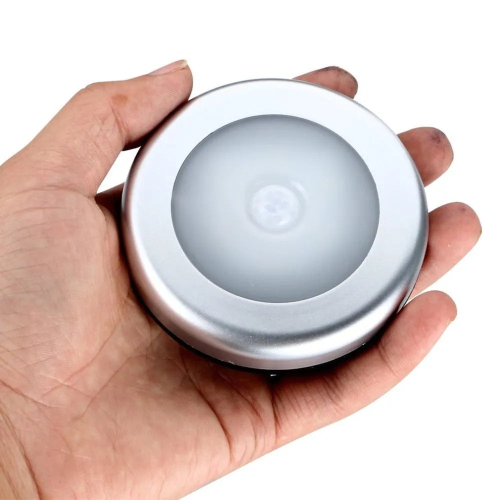 Silver wireless motion sensor night light with circular design and LED illumination