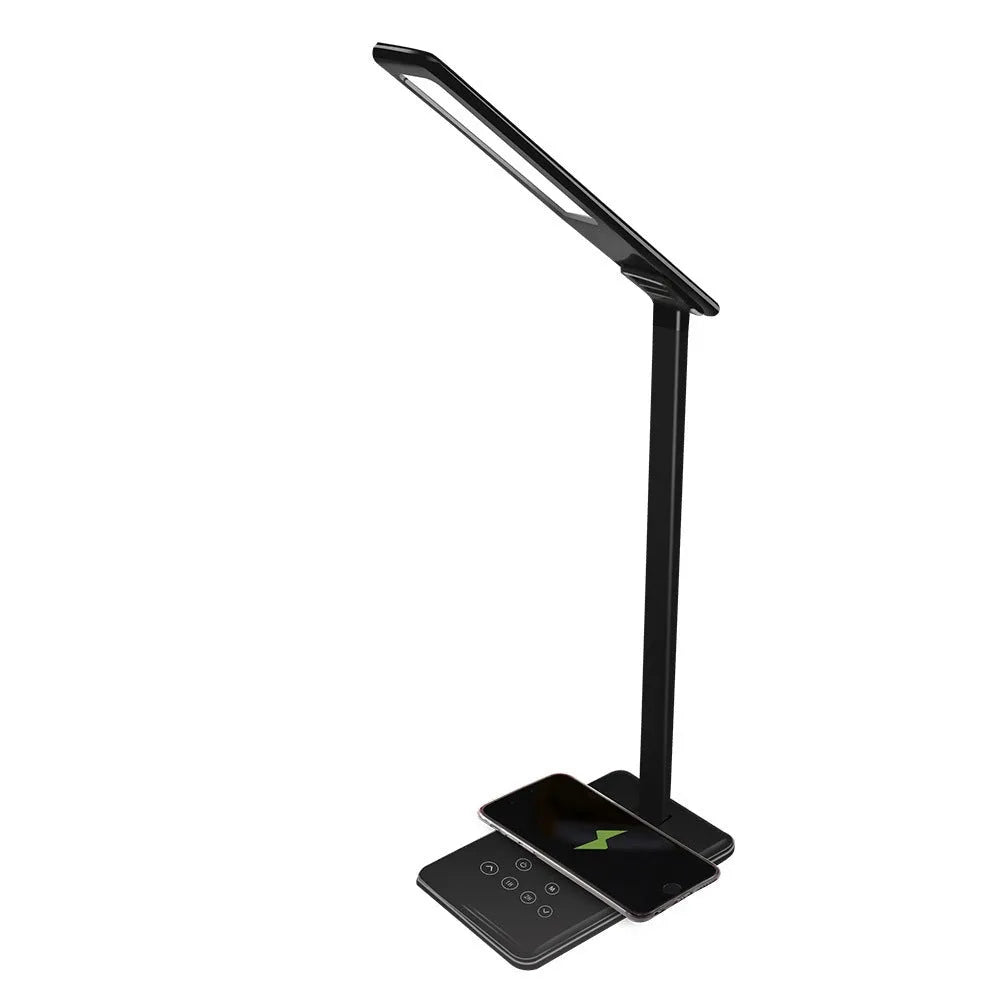 Black wireless charging desk lamp with touch switch and USB cable on a wooden desk.