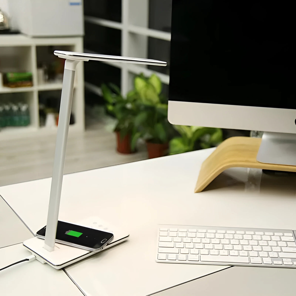 Black wireless charging desk lamp with touch switch and USB cable on a wooden desk.