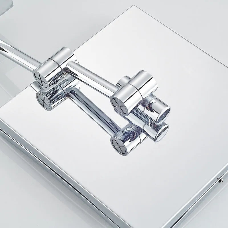 Stainless steel folding makeup mirror with a large silver mirror lens on a flat surface.