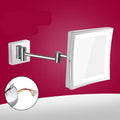 Stainless steel folding makeup mirror with a large silver mirror lens on a flat surface.