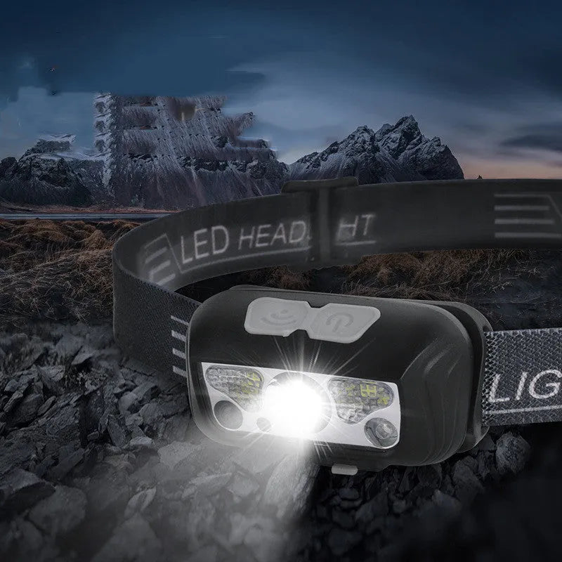 Black USB rechargeable sensor headlight with red LED running lights, shown on a head strap.