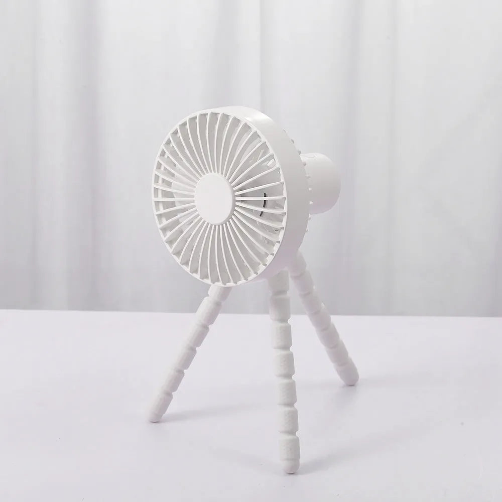 Compact portable desktop fan with flexible tripod stand and bending head, shown in white colour on a desk.