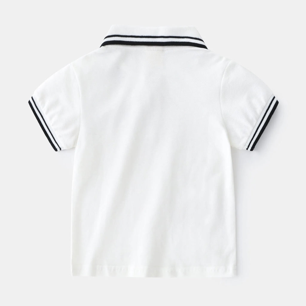 White and black boys' short sleeve cotton polo shirt laid flat.