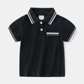 White and black boys' short sleeve cotton polo shirt laid flat.