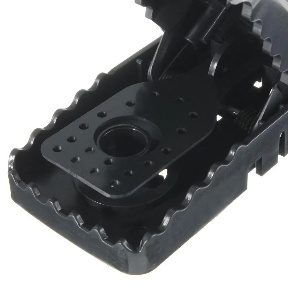 Six black plastic snapping mousetraps showing size and smooth surface.