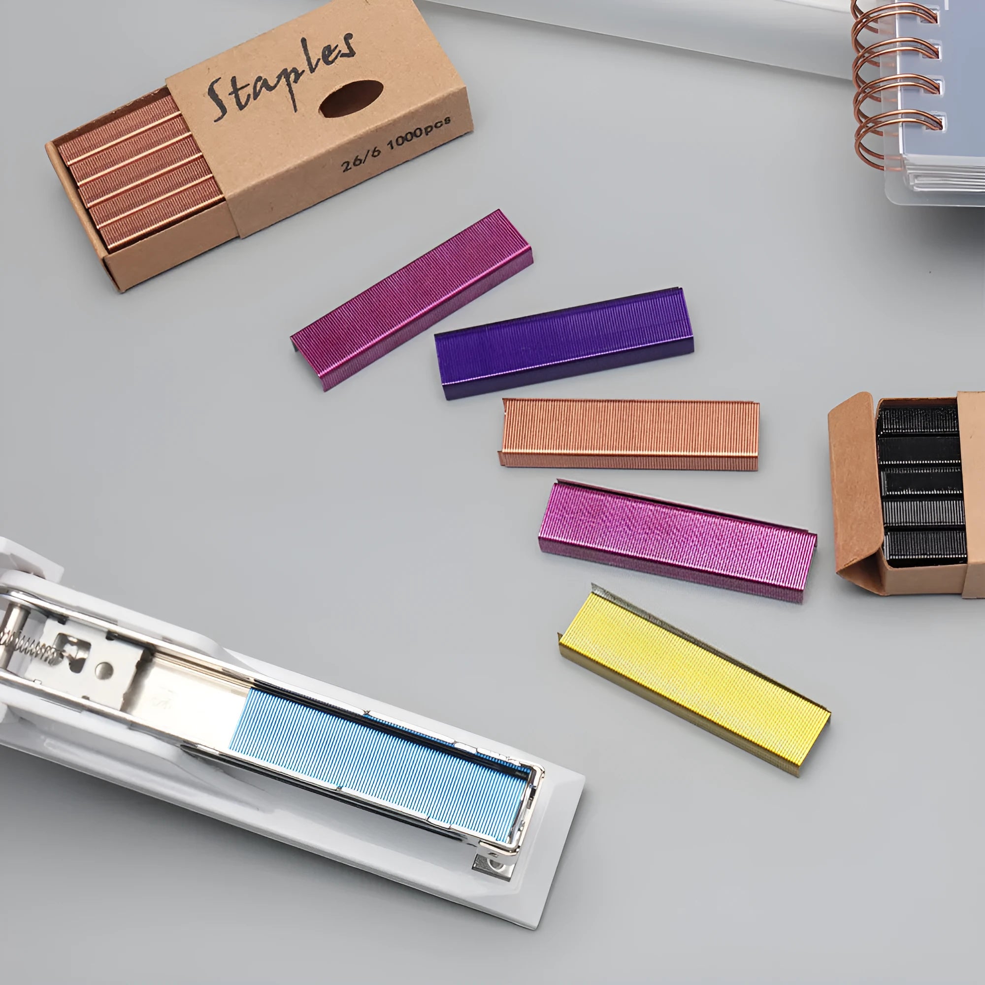 Box of 1000 metal office staples in rose gold, black, purple, and rose red colours