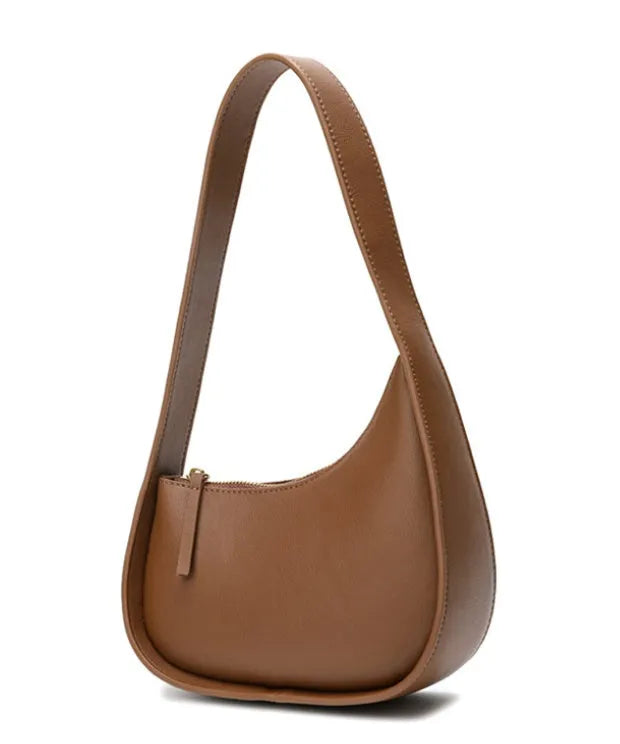 Small half-moon shaped leather ladies handbag with wide shoulder strap and zip opening