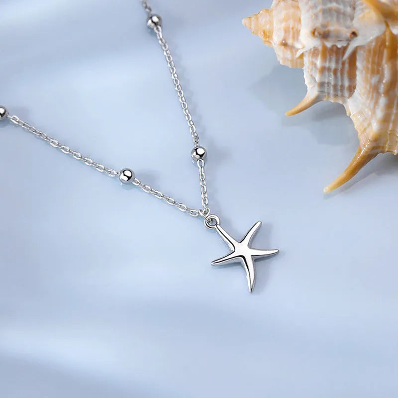 Sterling silver anklet with starfish charm and round beads on ankle