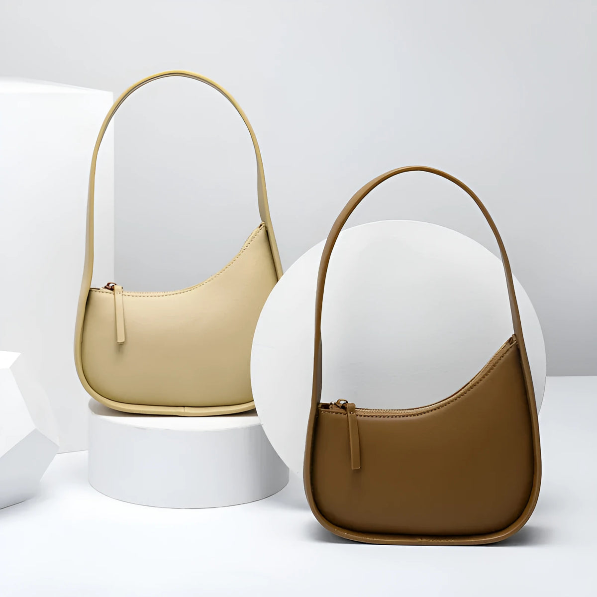 Small half-moon shaped leather ladies handbag with wide shoulder strap and zip opening