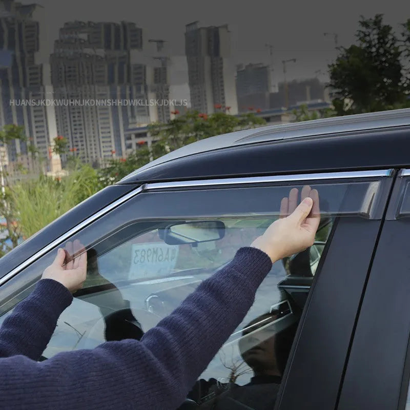 Black engineering plastic window deflectors installed on a silver 2023 Mitsubishi Outlander SUV side windows.
