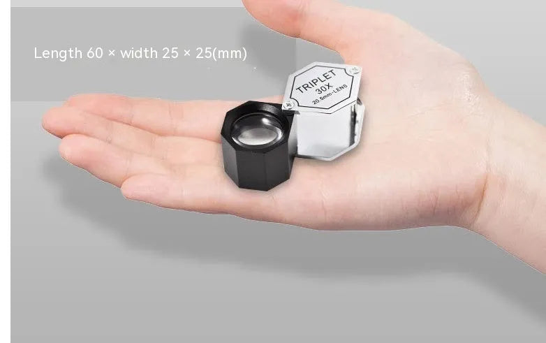 Handheld metal jeweller's loupe with optical glass lens for stamp and coin identification.
