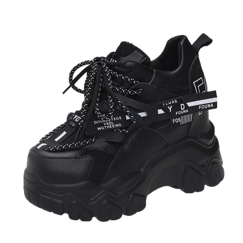 Women's white low-top platform trainers with mesh panels and a black cross-strap over the vamp.
