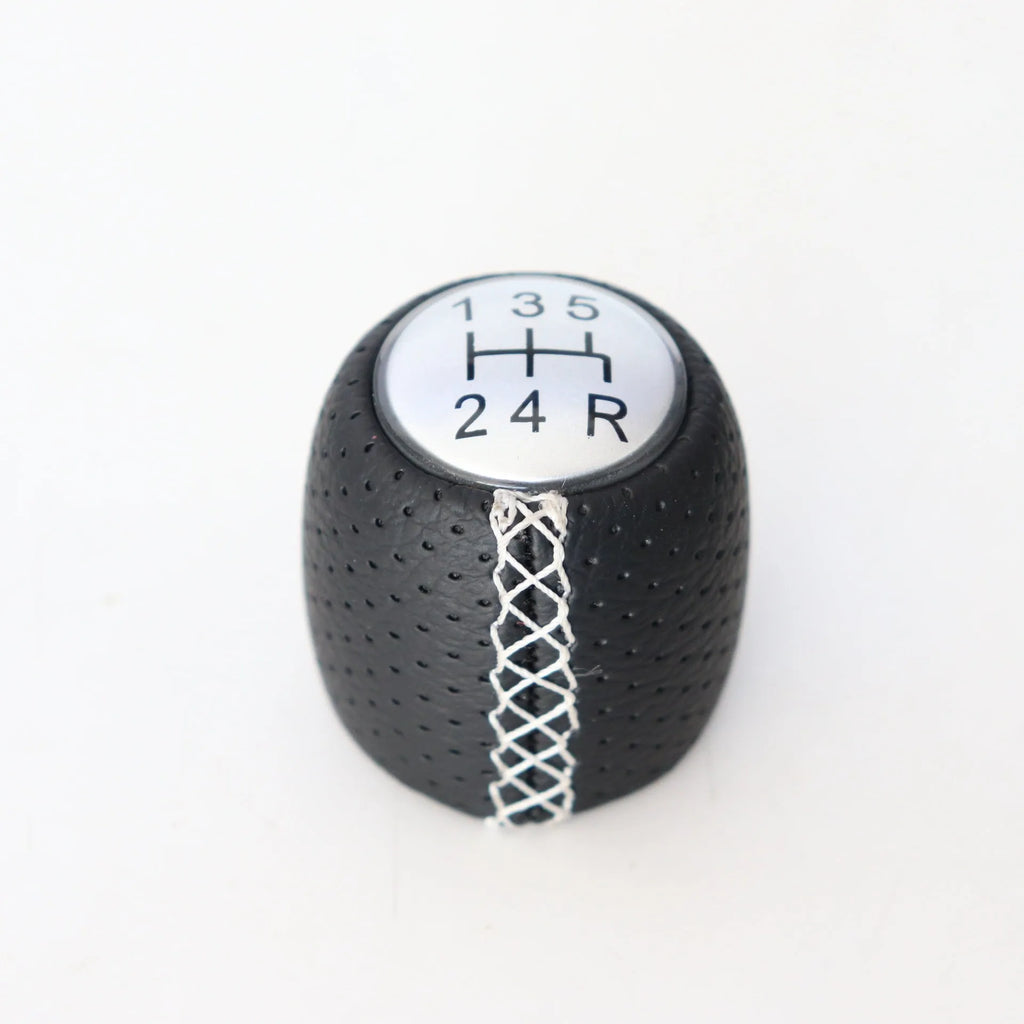 Black perforated leather-style gear shift knob for Alpha car on a 5-speed pattern matte cover.