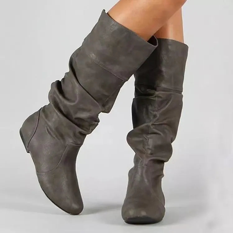 Women's black flat-heel slip-on ankle boots with round toe and high shaft on a rubber sole.