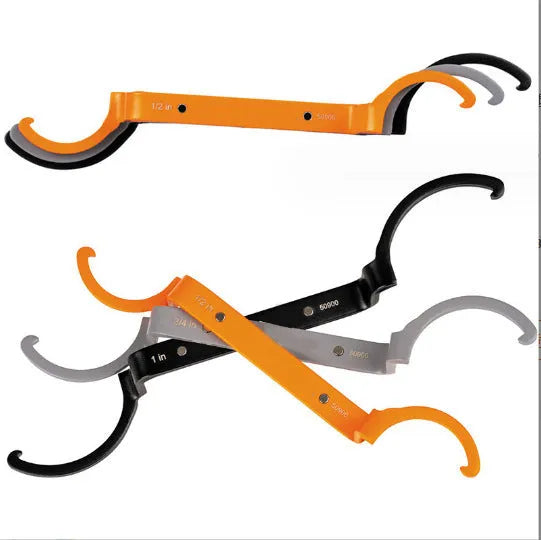 Orange, grey, and black crescent wrenches from a three-piece magnetic suction set for catheter locking.