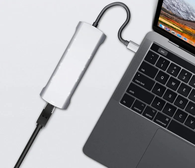 Grey aluminium USB-C docking station with HDMI, VGA, and USB 3.0 ports.