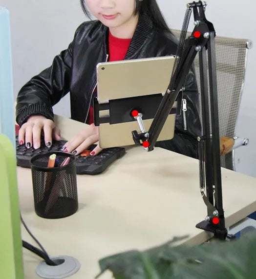 Black adjustable phone tablet stand with 360-degree rotating head on wooden desk