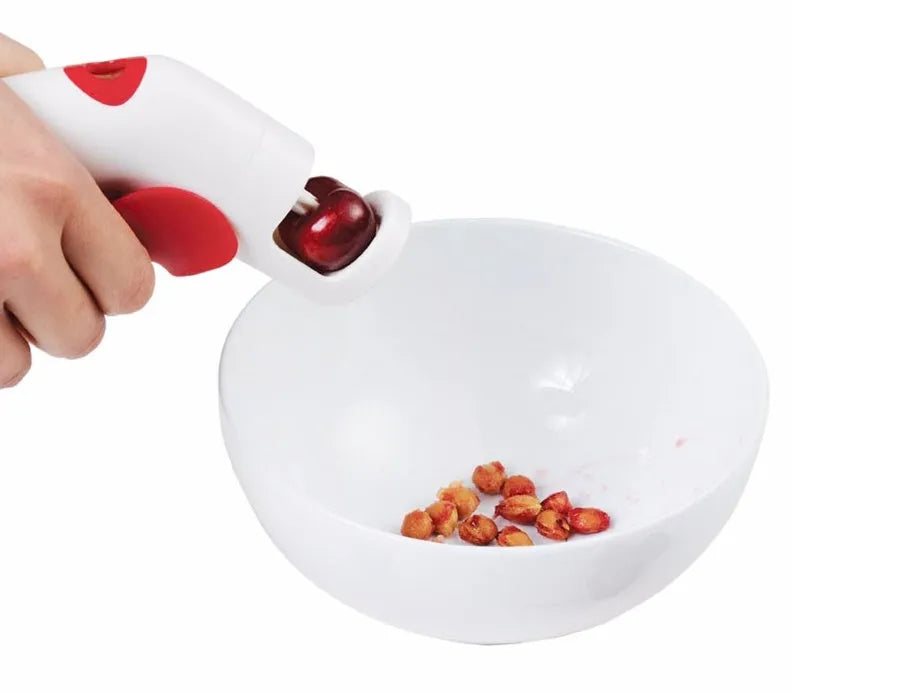 Stainless steel cherry pitter kitchen gadget with soft grip handles for removing stones from fruit.