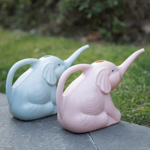 Pink baby elephant-shaped watering can with a long spout and baby bottle handle on a table.