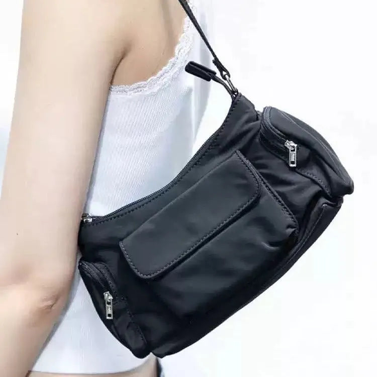 Black nylon shoulder bag with double pockets and side line detail, showing compact dimensions