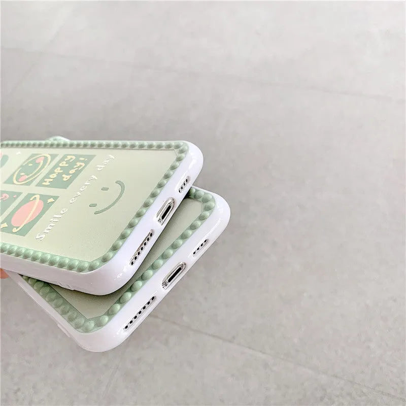 Green iPhone case with geometric smiley face design and polka dot frame on a TPU back cover.