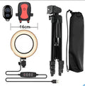 Adjustable silver aluminium phone tripod stand extended to medium height with phone attached.