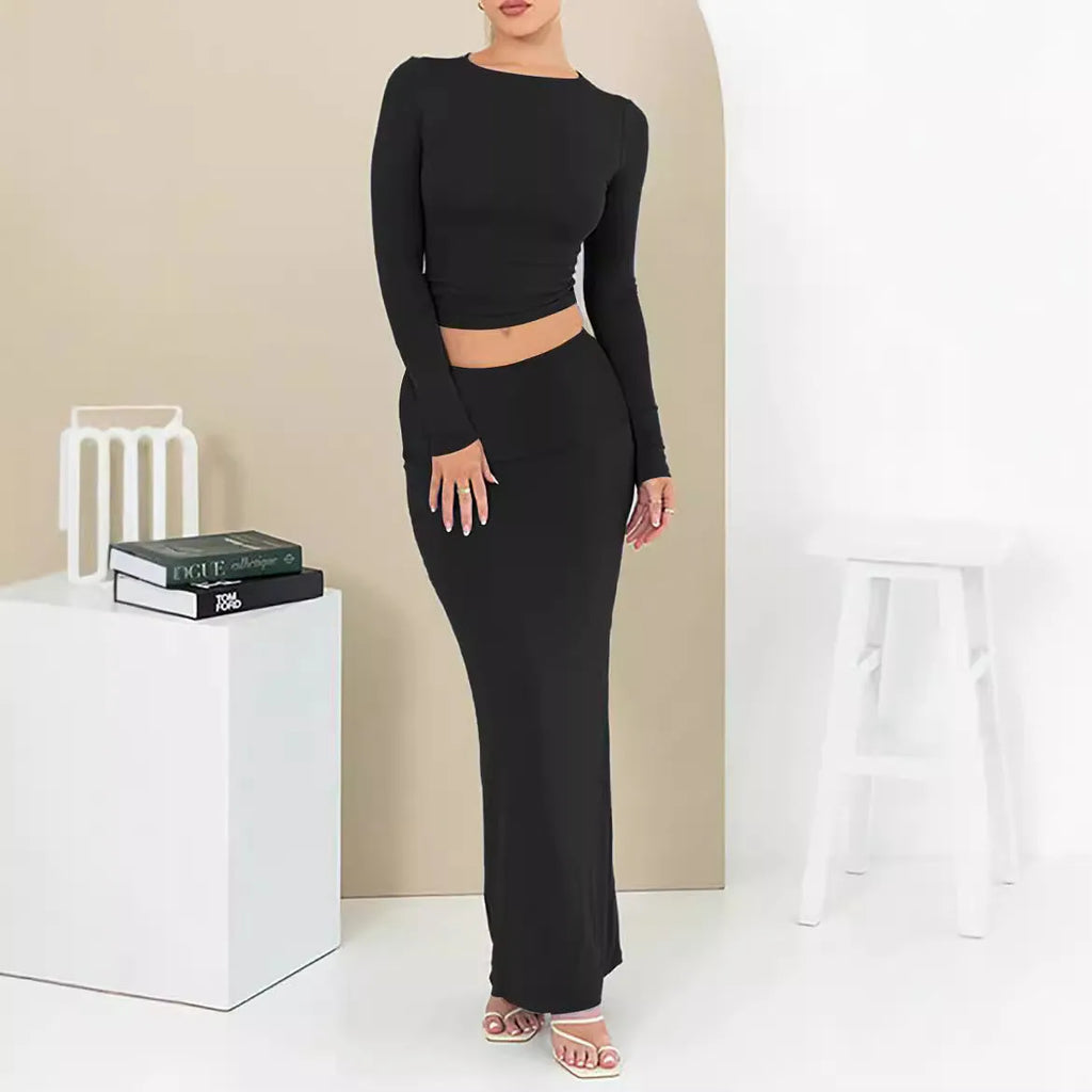 Women's black polyester two-piece suit with exposed navel top and long skirt.