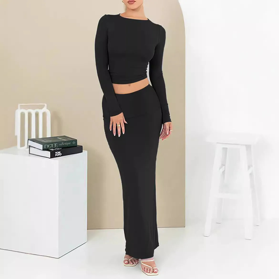 Women's black polyester two-piece suit with exposed navel top and long skirt.