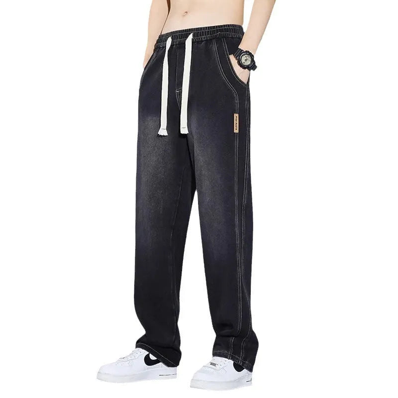 Men's loose fit straight leg cotton denim jeans with elastic waist and rope closure, available in four colours