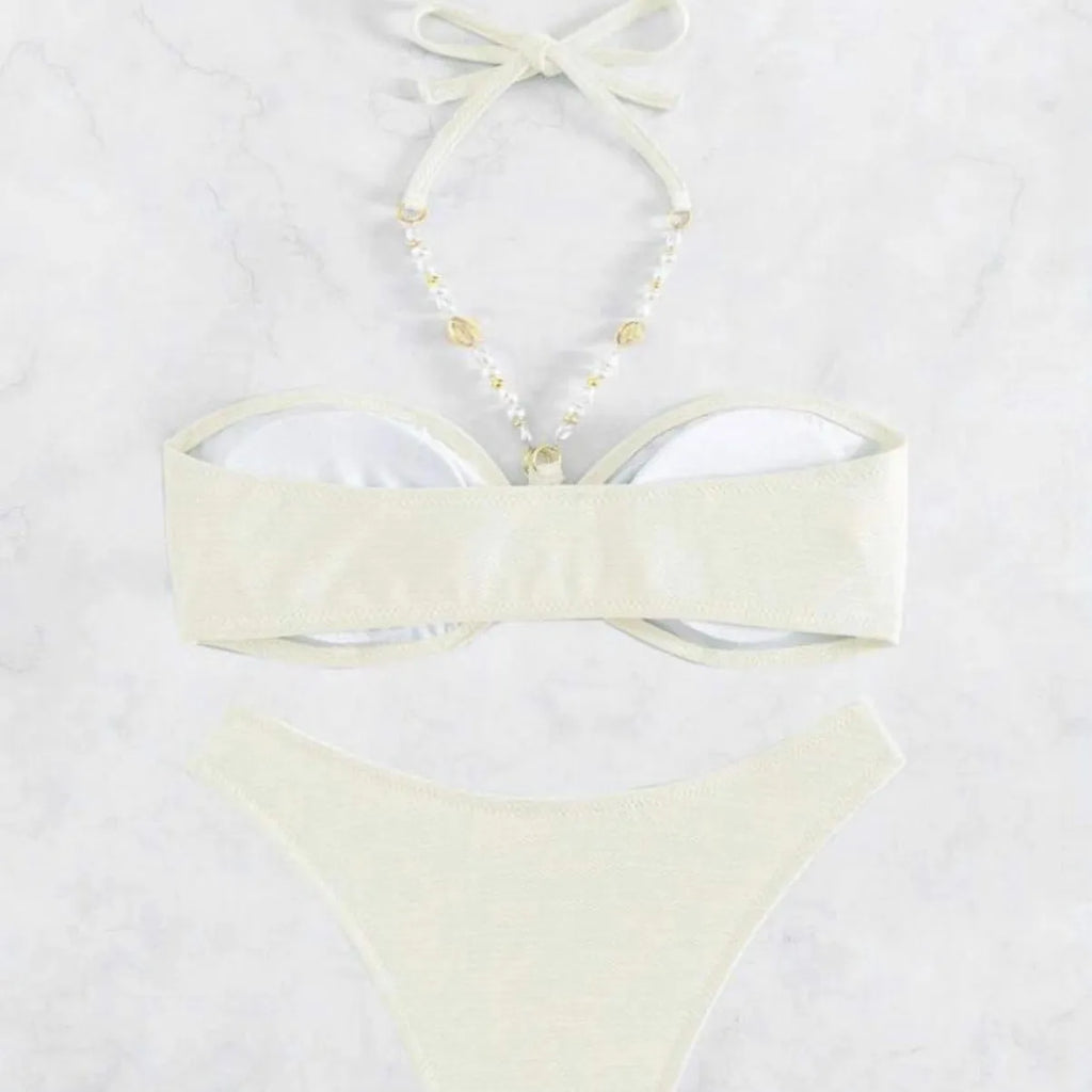 Women's halter-neck bikini swimwear set in a solid colour, shown on a model.