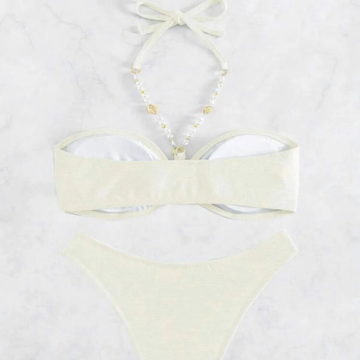 Women's halter-neck bikini swimwear set in a solid colour, shown on a model.
