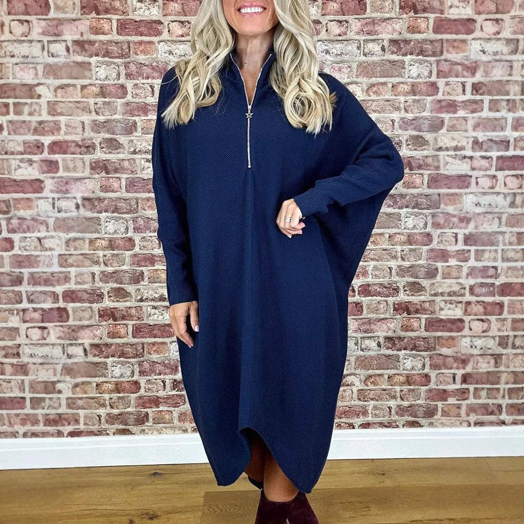 Dark green loose knitted women's dress with full front zipper and raglan sleeves on a hanger.