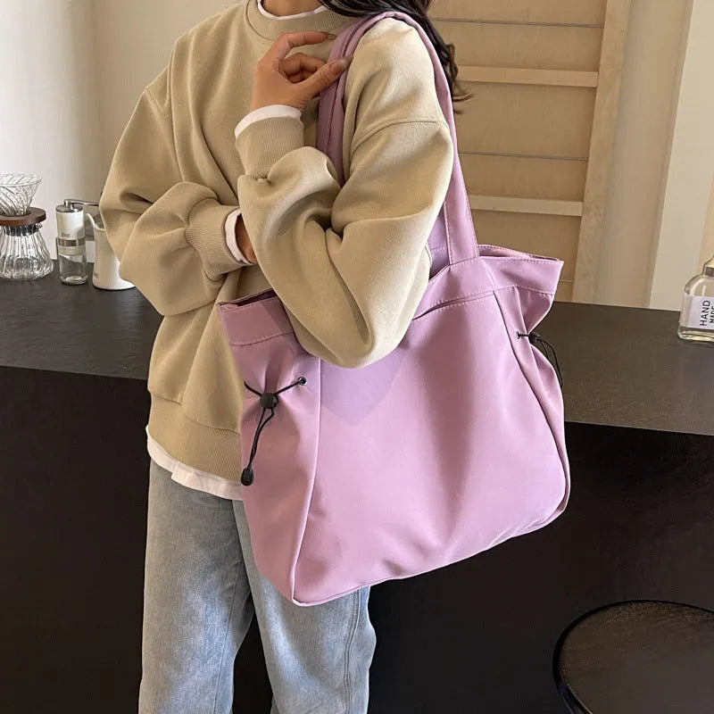 Soft Oxford cloth folding tote bag shown in a choice of five colours on a plain background.