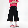 Red denim retro workwear shorts with multiple pockets and a wide-leg cropped fit on a model.