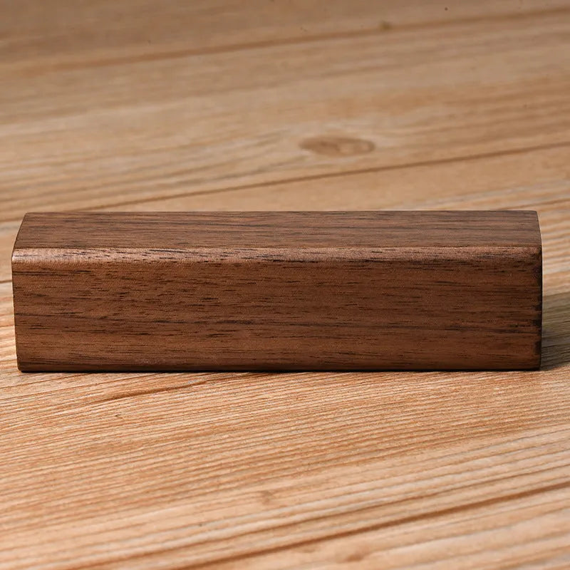 Brown walnut wood portable power bank with USB port next to its gift box.