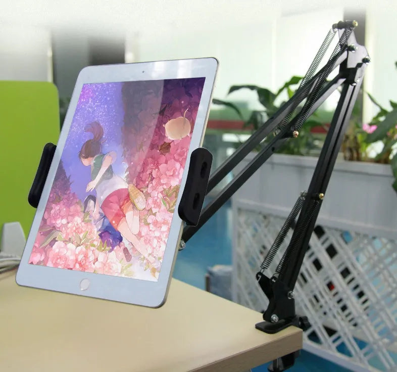 Black adjustable phone tablet stand with 360-degree rotating head on wooden desk