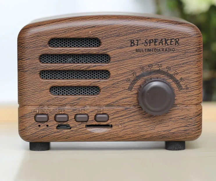 Compact vintage style Bluetooth speaker in wood grain finish on a wooden table