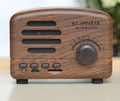 Compact vintage style Bluetooth speaker in wood grain finish on a wooden table