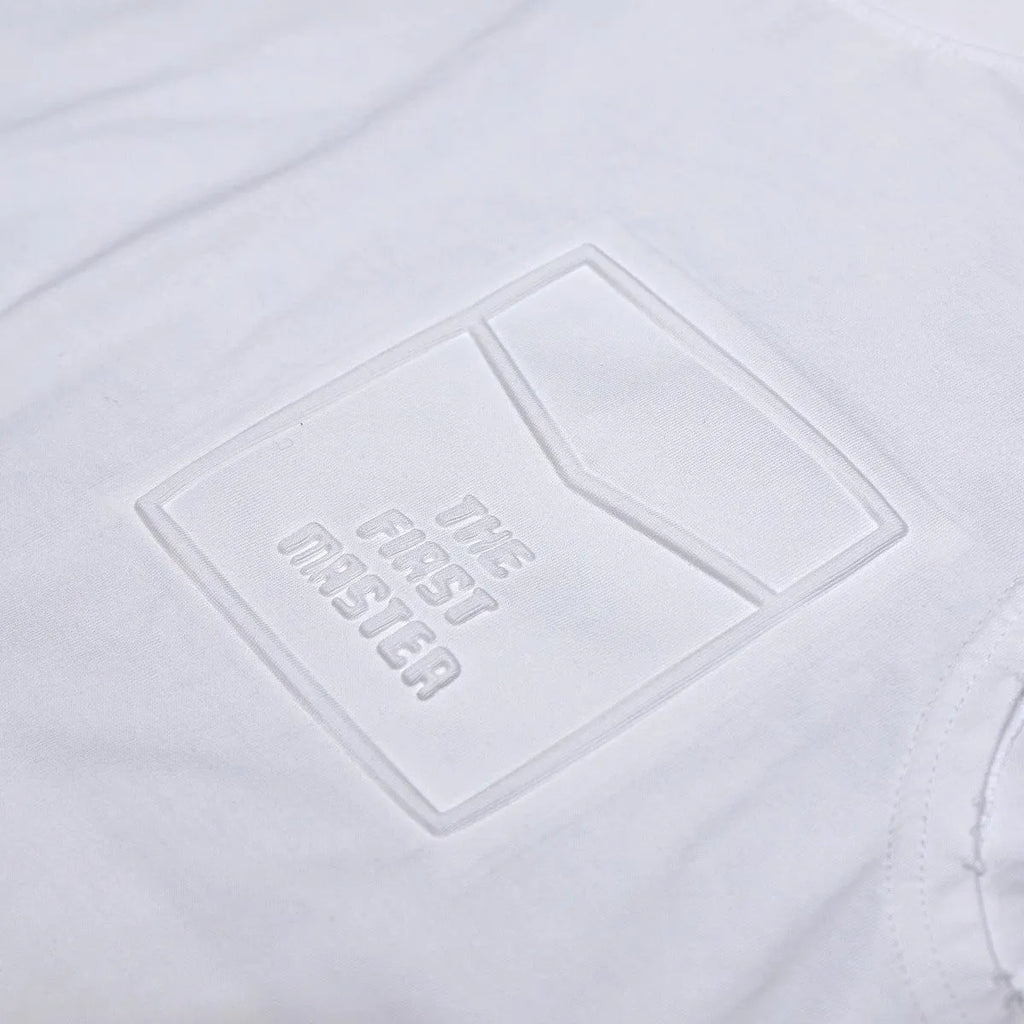 Loose fit solid colour cotton sleeveless t-shirt on a hanger, shown in white.