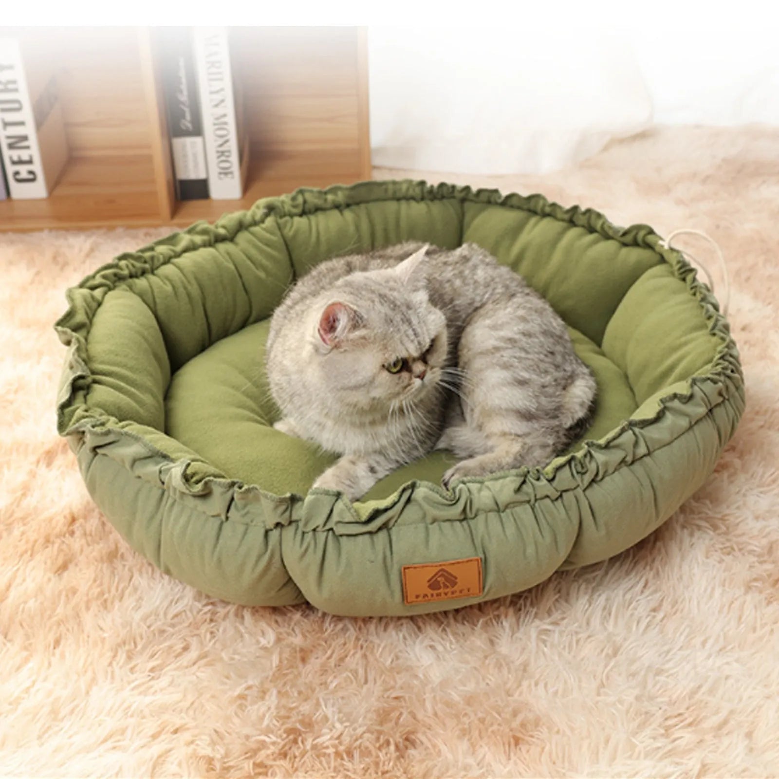 Grey reversible donut-shaped pet bed for cats and small dogs on a wooden floor.