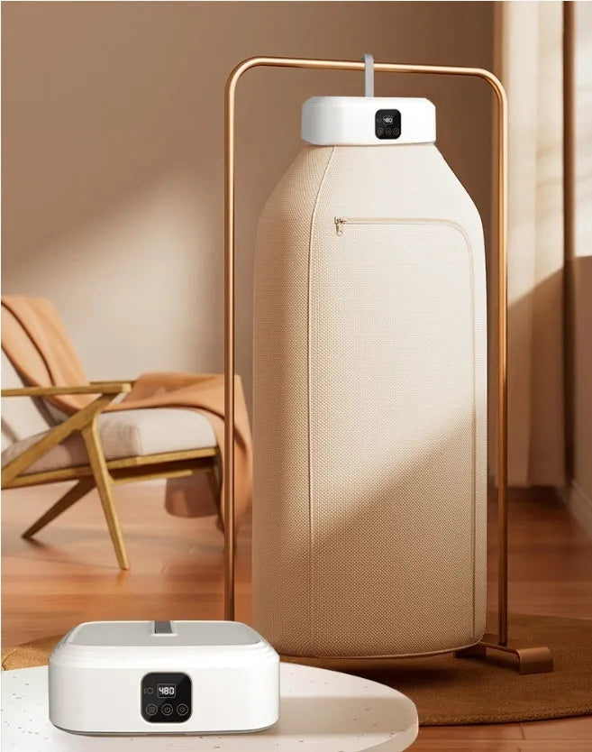 White cylindrical foldable clothes dryer with remote control on flat surface showing compact dimensions