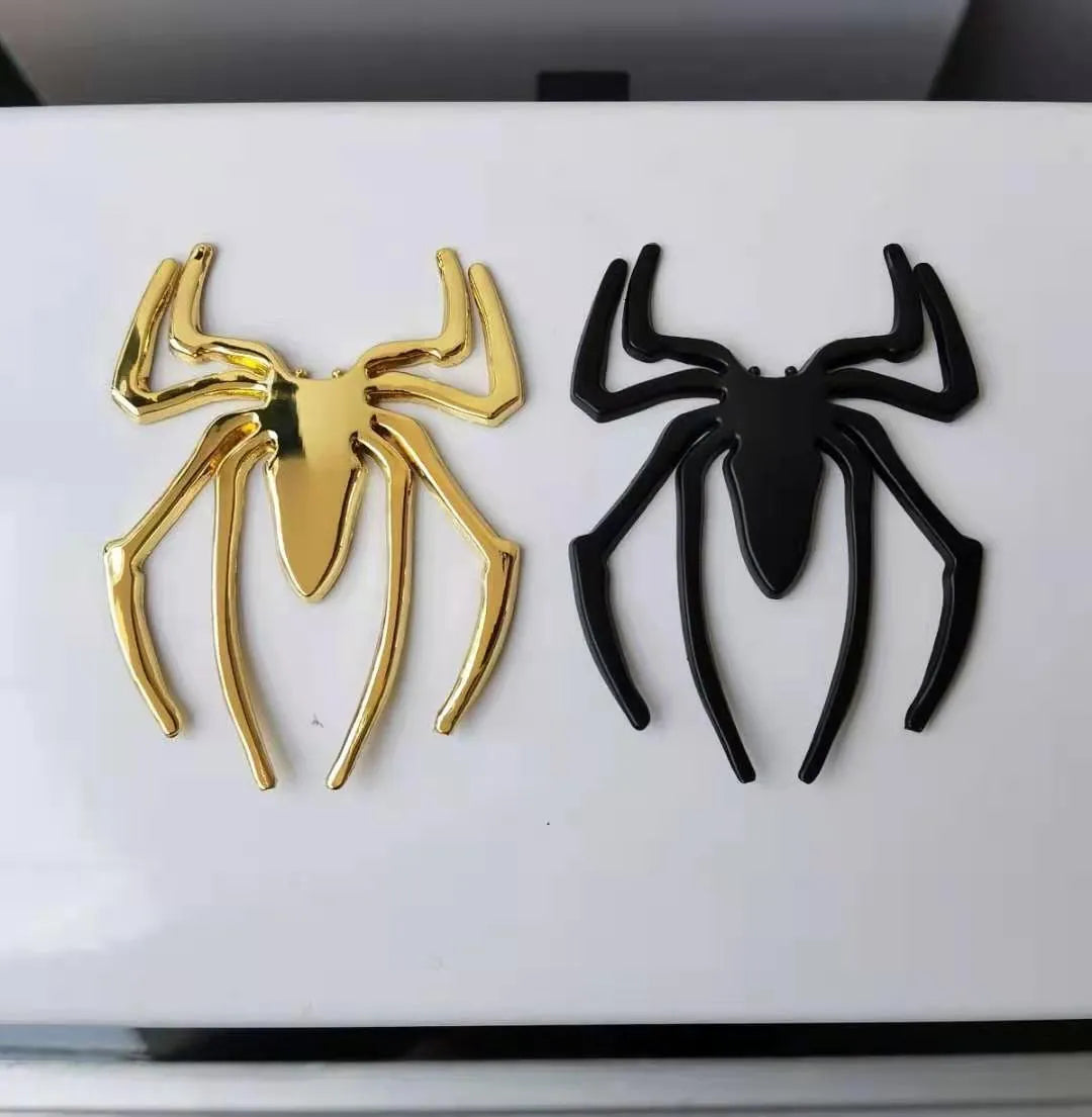 Three-dimensional metal spider bumper sticker in gold finish, measuring 7cm by 5cm.