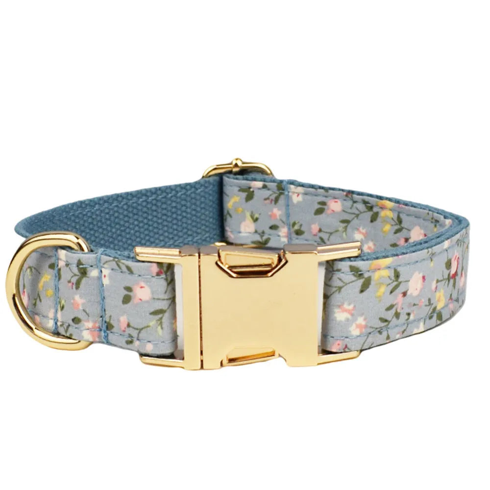 Blue floral patterned dog collar with matching accessories including leash, bow, vest, and poop bag