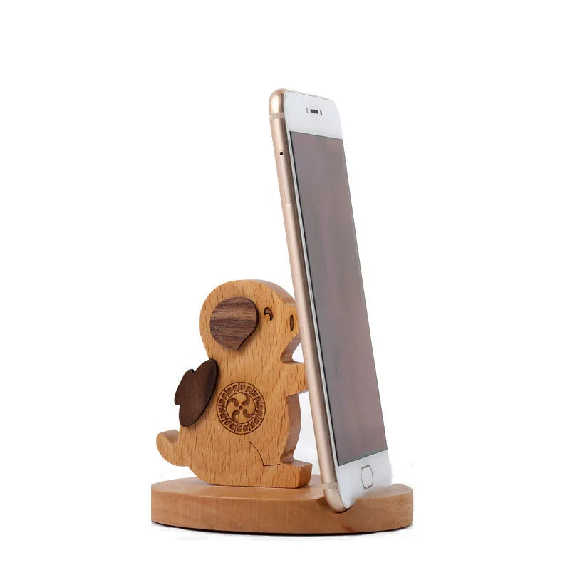 Solid beech wood mobile phone stand with a decorative resin animal ornament and a coin slot.