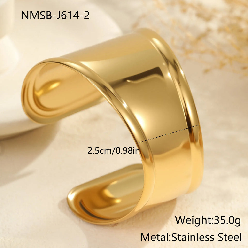 Women's stainless steel bracelet with 18K gold plating featuring geometric wave design and exaggerated wide band