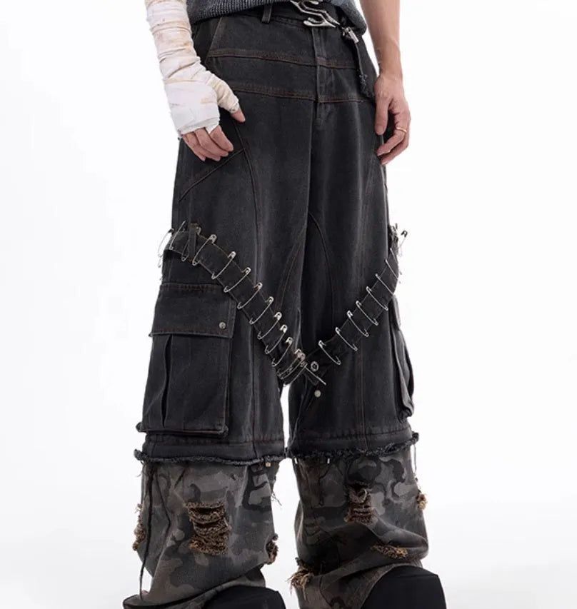 Men's grey cotton jeans with camouflage print, splicing panels, and decorative pin and ribbon details.